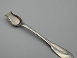 silver spoon with a spoon handle on a gray surface