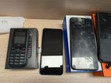 three cell phones sitting on a table next to each other