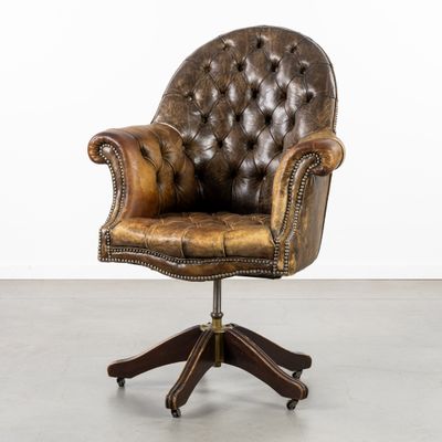 une chaise de bureau en cuir marron, équipée de roulettes et dotée d'un piètement en bois