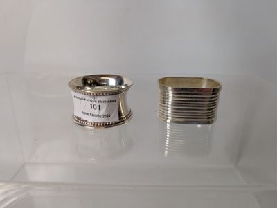 a silver ring and a silver cup on a glass shelf