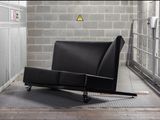 a black chair that is in a room with a brick wall