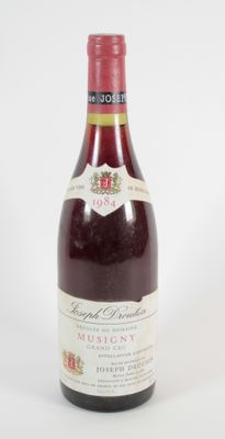 une vieille bouteille de vin posée sur une table blanche