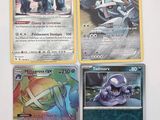 quatre cartes Pokémon différentes posées sur une table blanche