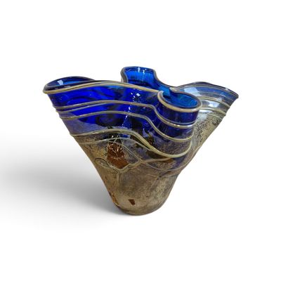 a blue glass vase sitting on top of a white surface