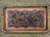 a brown and black tray sitting on top of a wicker table