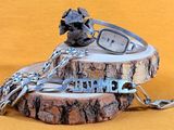 a silver bracelet with a clock on it and a chain around it