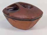 a small brown bowl with a lid on a white surface