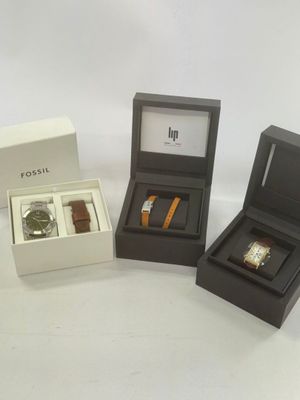 three boxes with watches and a watch in them on a white surface