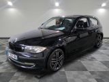 une photo d'une voiture bmw noire garée dans un garage