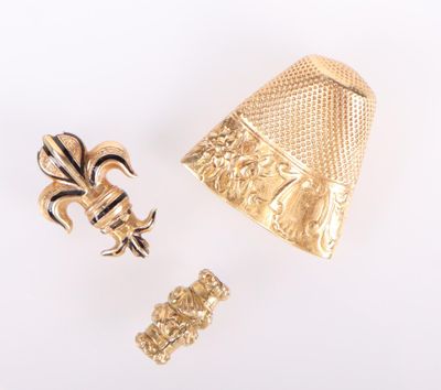 deux bijoux en or posés sur une surface blanche, sur fond blanc