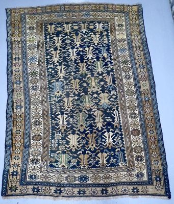 un tapis oriental bleu et or posé sur une surface blanche