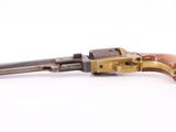 an old revolver with a wooden handle on a white surface