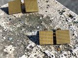 une paire de boucles d'oreilles en or posée sur une dalle de béton