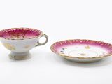 two cups and saucers are sitting side by side on a white surface