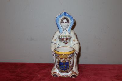 une figurine représentant une femme tenant une tasse