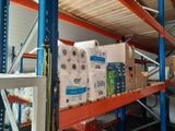de nombreux rouleaux de papier toilette sur une étagère dans un entrepôt