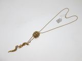 un gros plan d'un collier posé sur une surface blanche, auquel est accrochée une étiquette