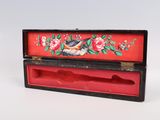 a red box with a bird and flowers painted on it