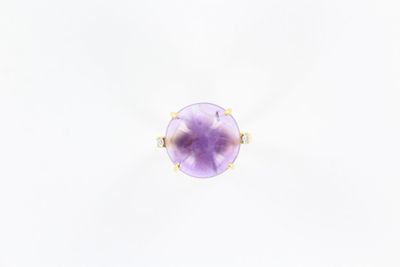 une bague en or jaune sertie d'une pierre violette