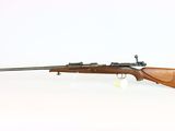 a rifle on a white surface with a white background