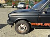 a black car with orange stripes parked in a parking lot