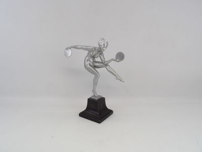 silver statue of a tennis player holding a racket on a white surface