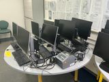 several computers are sitting on a table in front of a window