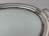 a silver tray with a mirror in it on a table