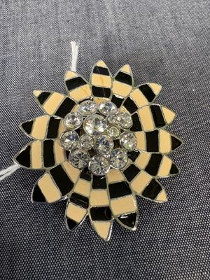 un gros plan sur une broche en forme de fleur en noir et blanc