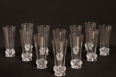 six verres à vin transparents sont alignés sur une surface noire