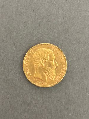 a close up of a gold coin on a gray surface
