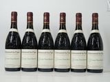 six bouteilles de vin sont alignées sur une table