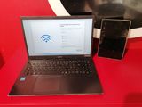 un ordinateur portable et un téléphone portable posés sur une table rouge