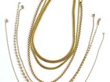 a group of gold chain necklaces on a white background