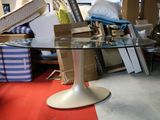 a glass table with a white base in the middle of a room