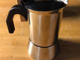 a coffee pot sitting on a table with a box in the background