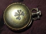 un gros plan d'une montre de poche en or ornée d'une fleur