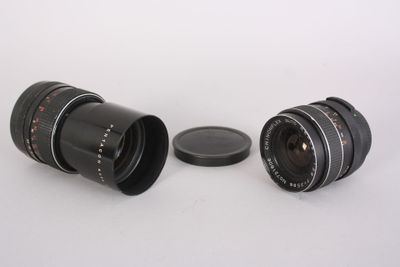two lenses sitting next to each other on a white surface