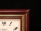 a small clock with roman numerals on the face of it