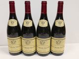 quatre bouteilles de vin sont alignées sur une table