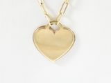 the gold heart pendant is attached to a gold chain