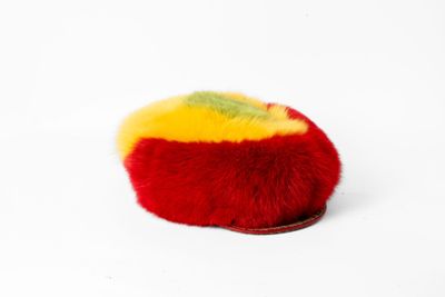 un pompon rouge et jaune sur un fond blanc