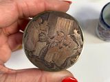 a person holding a small metal object with a picture on it