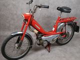 un vélo rouge avec une selle noire sur fond gris