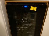 a black refrigerator with a yellow sticker on it