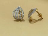 two tone gold and diamond earrings on a beige background