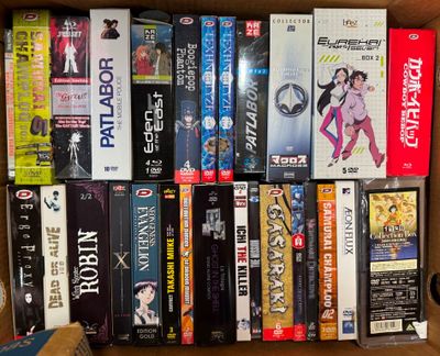 un grand nombre de dvd dans une boîte posée sur le sol