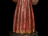 statue of a man with a beard and a red robe holding a ball