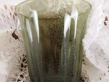 un verre vert posé sur un napperon napperon