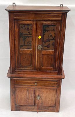 une petite armoire en bois munie d'une porte vitrée